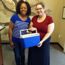 Milk donor and milk bank staff pose with donor's cooler