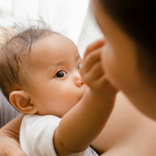 Breastfeeding baby grabbing mother's nose