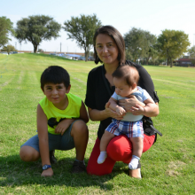 Mother holding son, older son sitting next to her