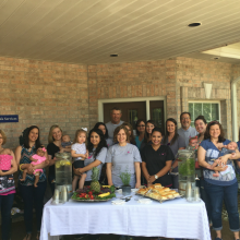 Group posed around table of refreshments at a grand opening