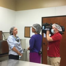 Cameraman filming reporter interviewing woman in lab