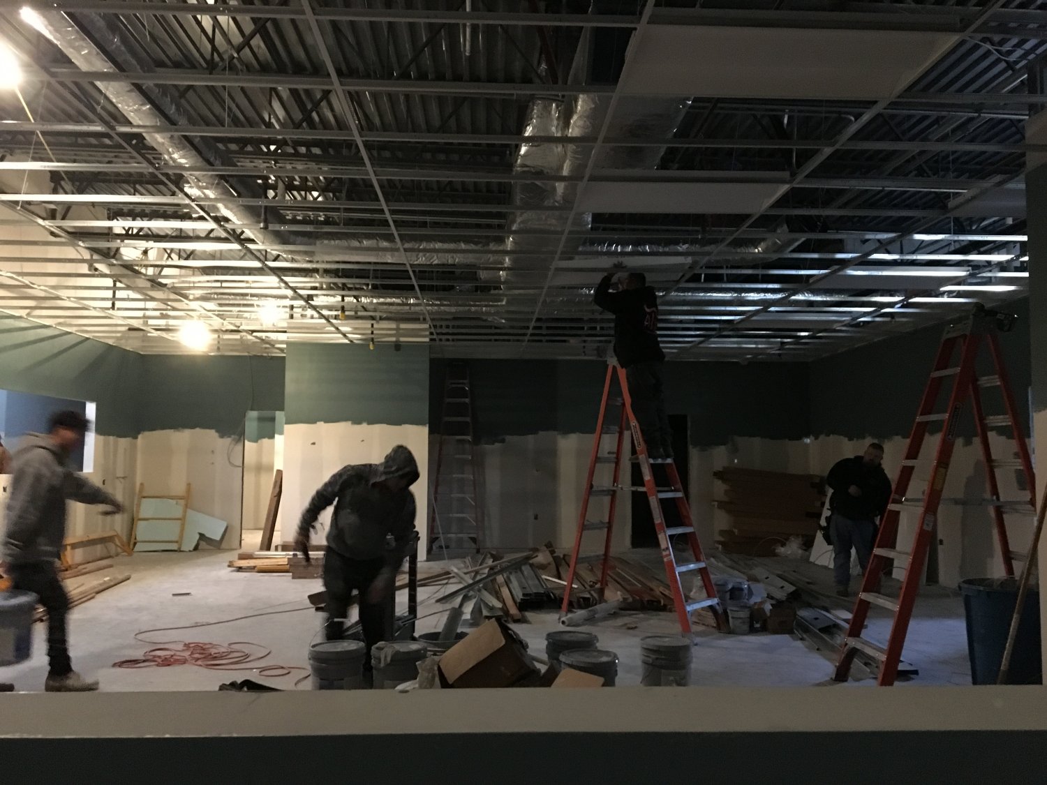 Three men working at indoor construction site