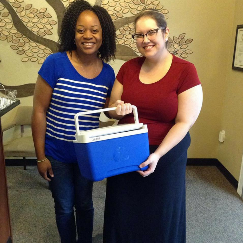 Milk donor and milk bank staff pose with donor's cooler