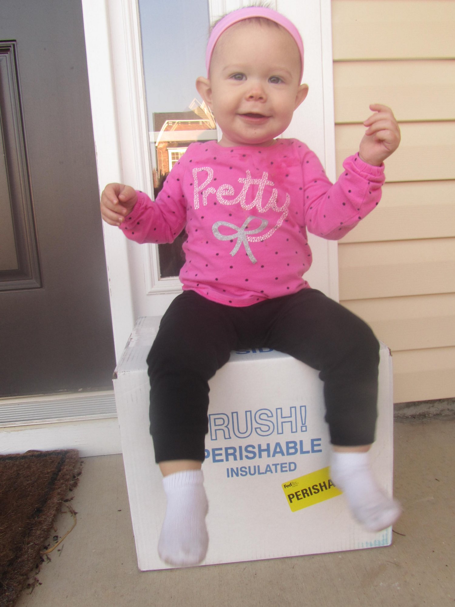 Baby sitting on top of shipping box