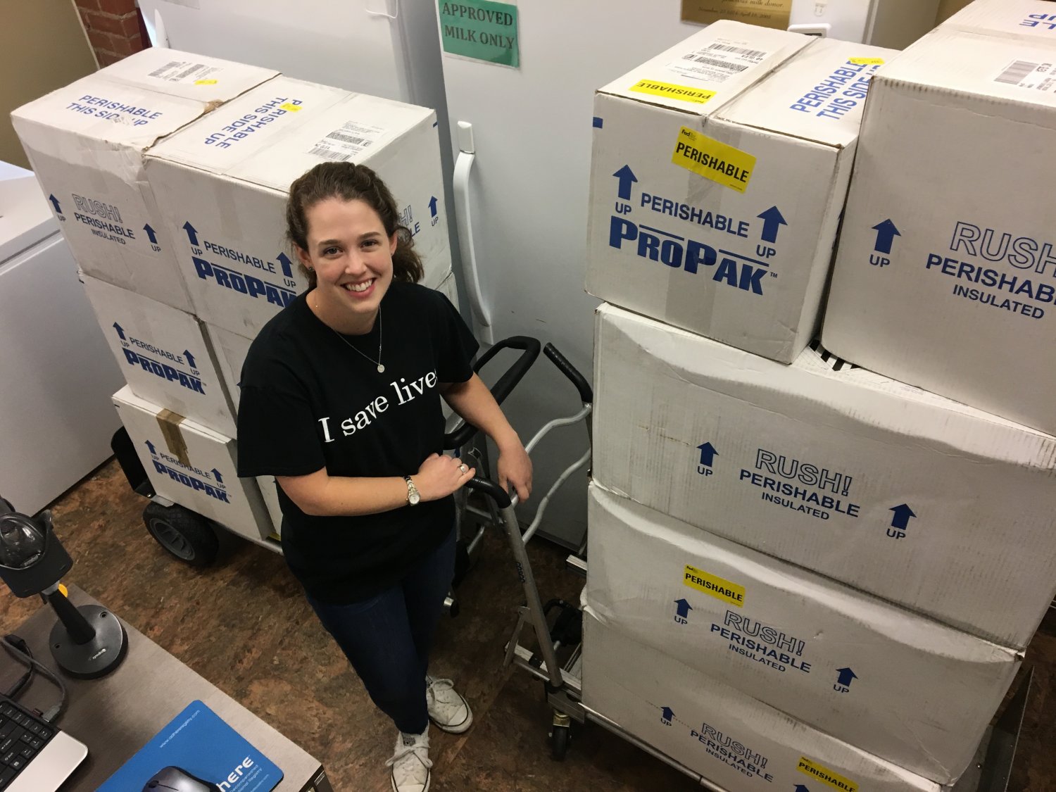 MMBNT staff standing with full shipping containers