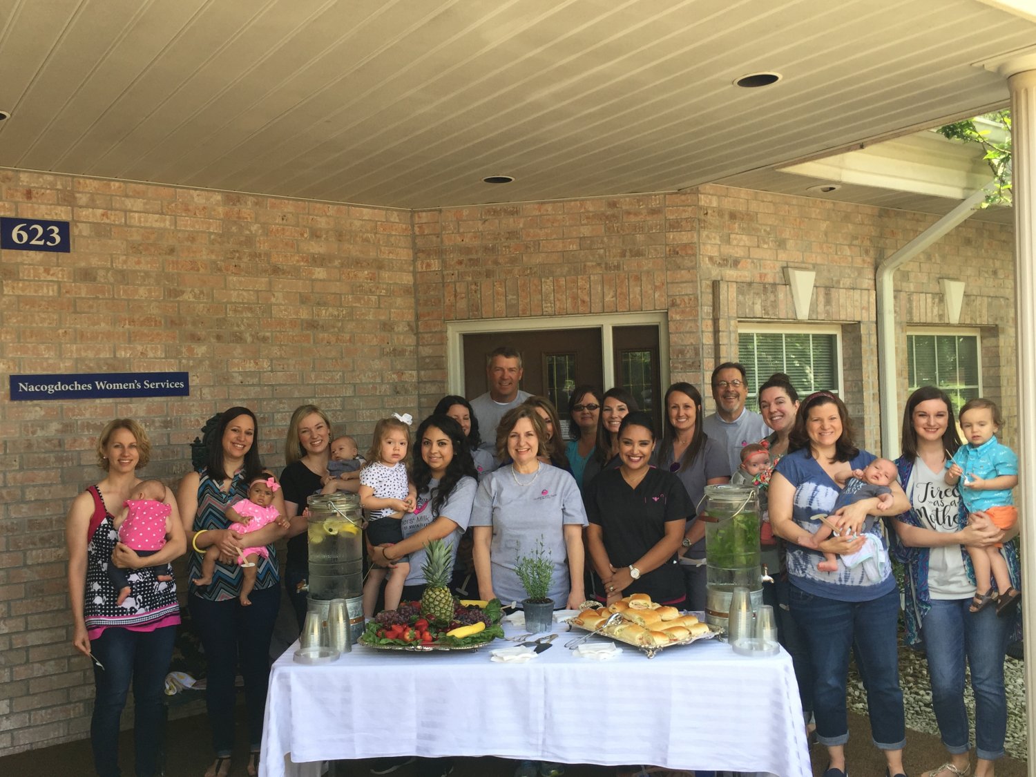 Group posed around table of refreshments at a grand opening