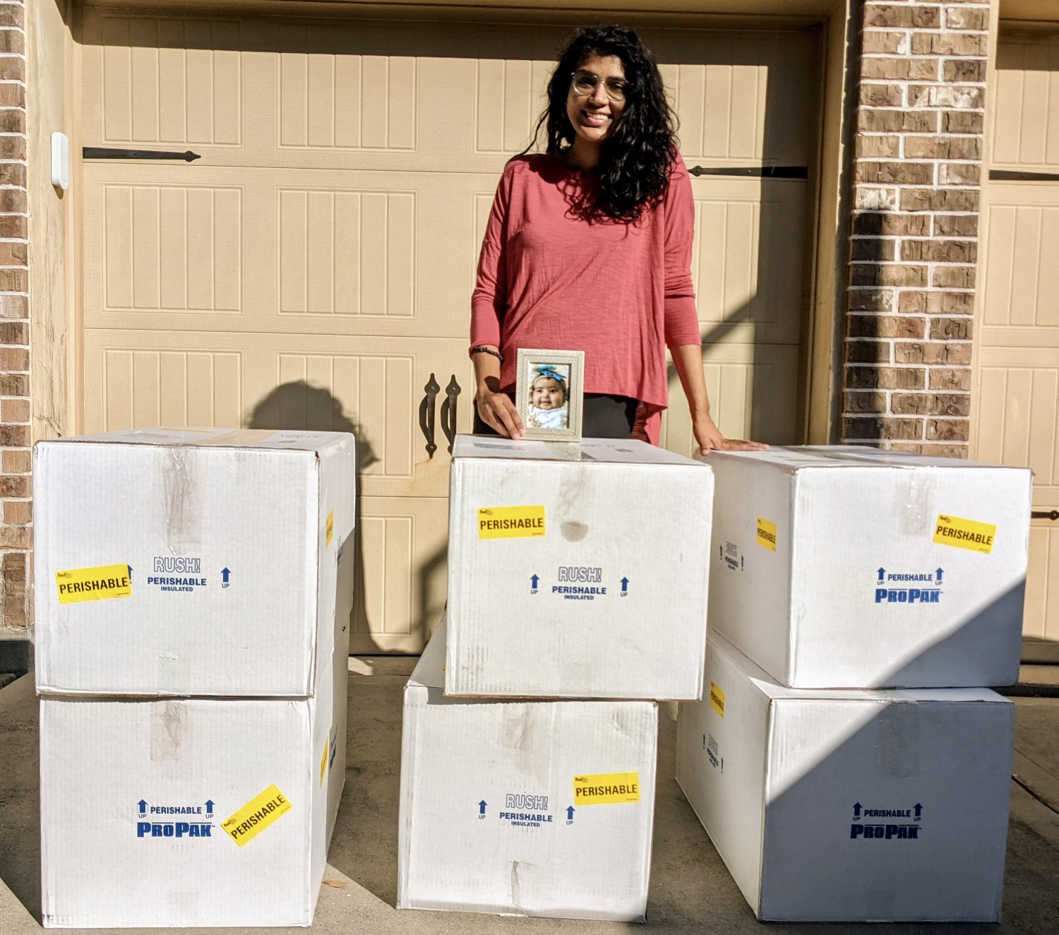 Verda with a picture of Noor and boxes of her donor milk.