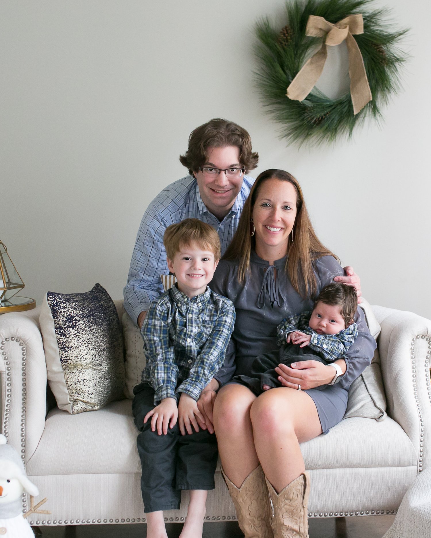Mother, father, young son and infant son on a couch