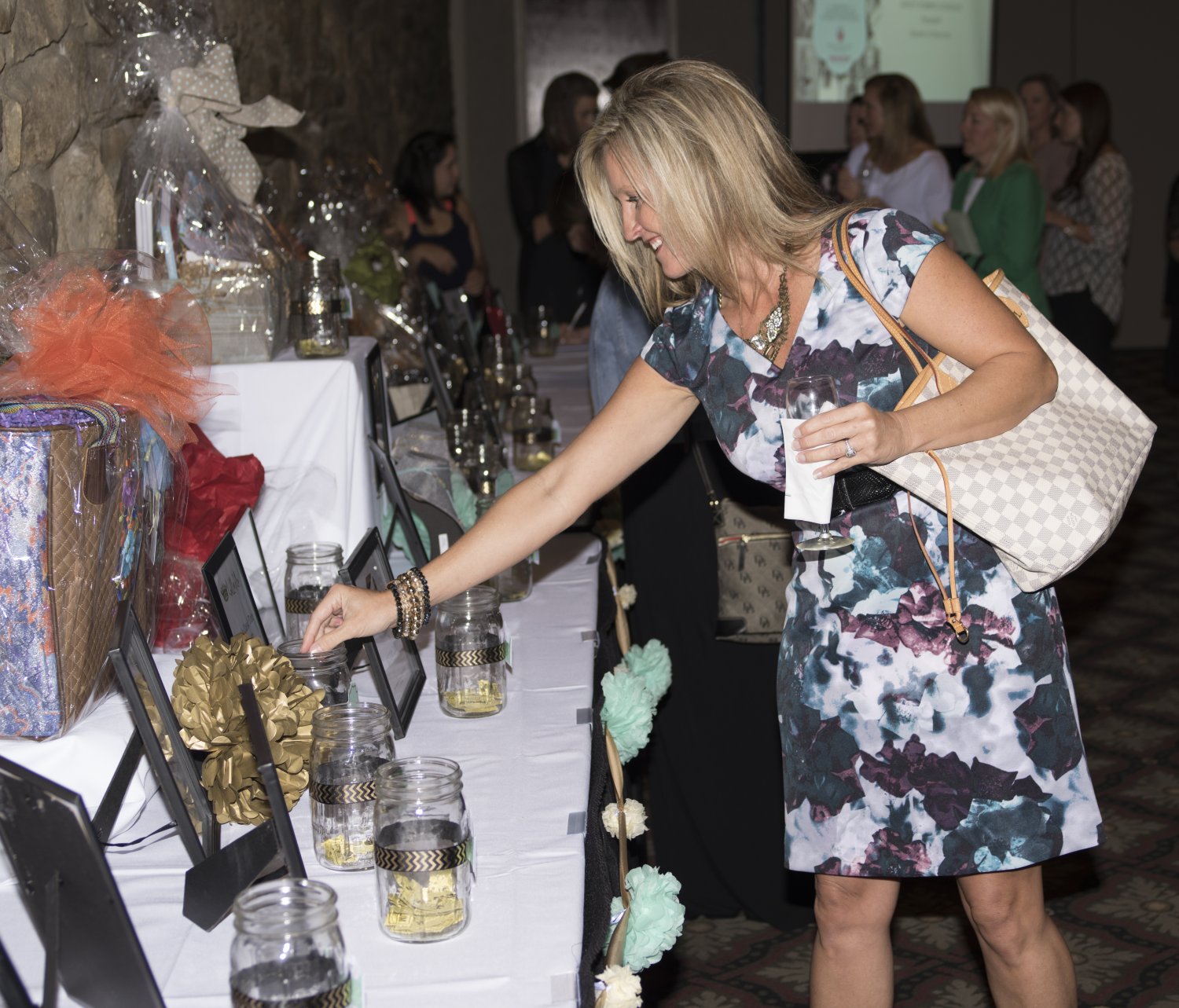 Woman placing raffle tickets in a jar